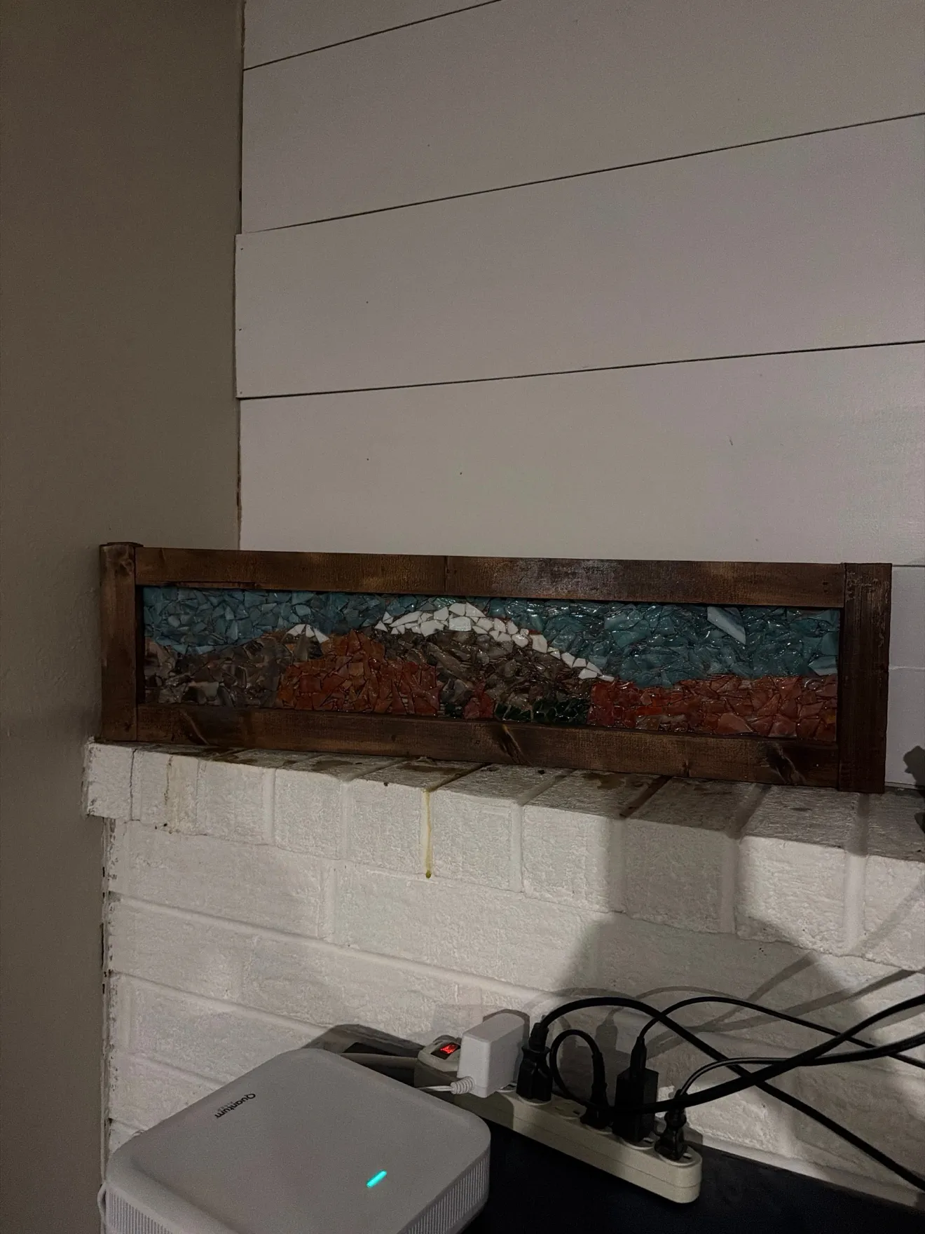 Framed hand-cut mountain mosaic on a mantel